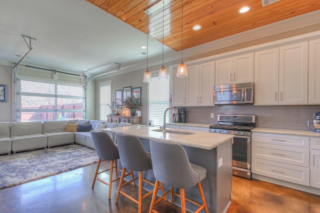 kitchen featuring stainless steel appliances, a sink, concrete floors, plenty of natural light, and recessed lighting