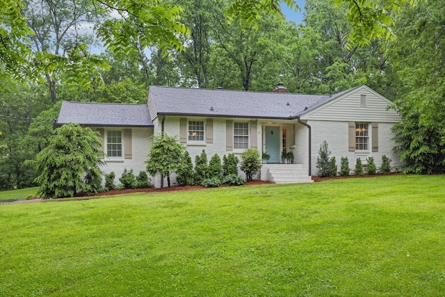 single story home featuring brick siding, a front lawn, and a chimney