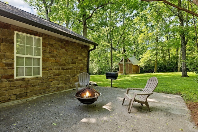 view of patio / terrace with an outdoor fire pit and an outdoor structure
