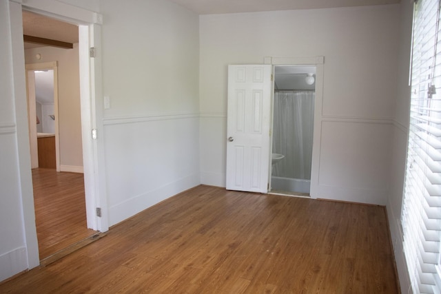 unfurnished bedroom with wood finished floors and baseboards