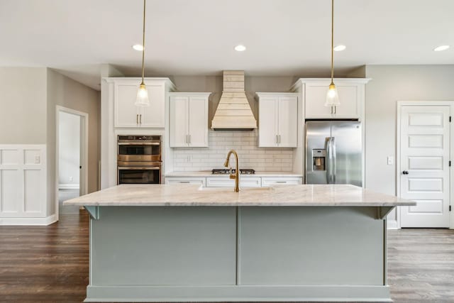 7575 Carthage Hwy, Lebanon, TN 37087 - kitchen with appliances with stainless steel finishes, custom range hood, a center island with sink, white cabinets, and decorative backsplash