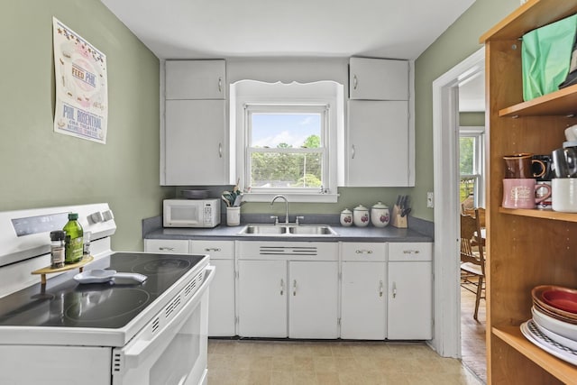 kitchen featuring white appliances, a sink, white cabinets, dark countertops, and open shelves