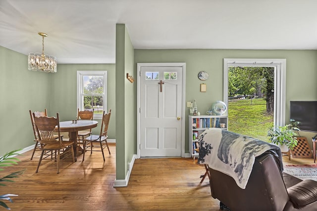 dining room featuring a chandelier, wood finished floors, and baseboards