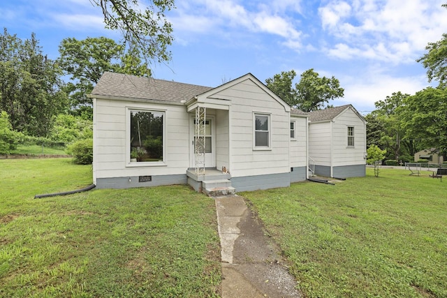 bungalow-style home featuring a front lawn, crawl space, and roof with shingles
