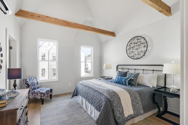 bedroom featuring an AC wall unit, wood finished floors, and baseboards