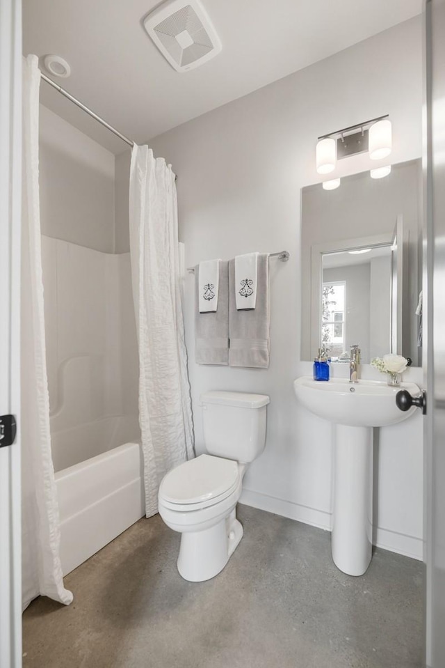 bathroom with finished concrete flooring, toilet, and shower / tub combo with curtain