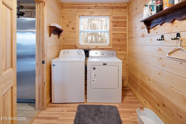 2819 Pine Haven Dr, Sevierville, TN 37862 - laundry room with washing machine and dryer, wooden walls, and light wood-style flooring
