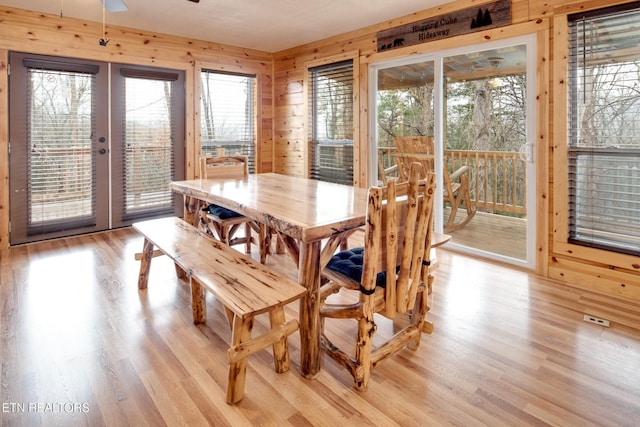 2819 Pine Haven Dr, Sevierville, TN 37862 - dining room featuring light wood-style flooring, french doors, wood walls, and a ceiling fan