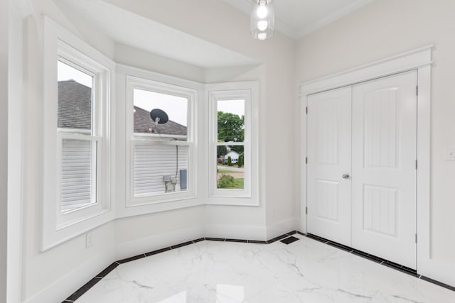 foyer with marble tiled flooring and baseboards
