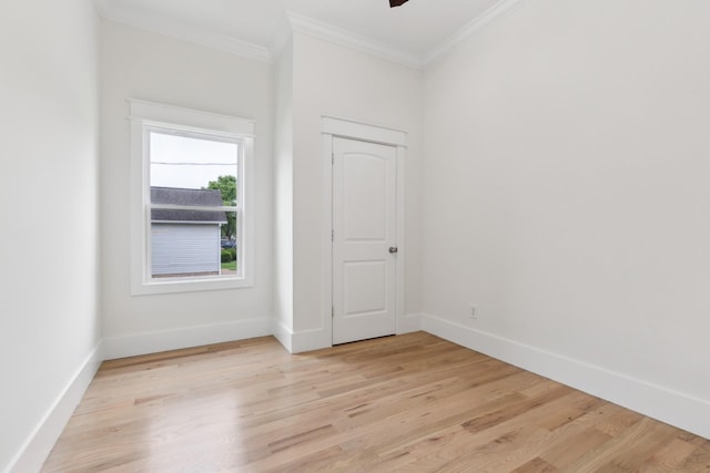unfurnished room featuring light wood-style flooring, crown molding, and baseboards