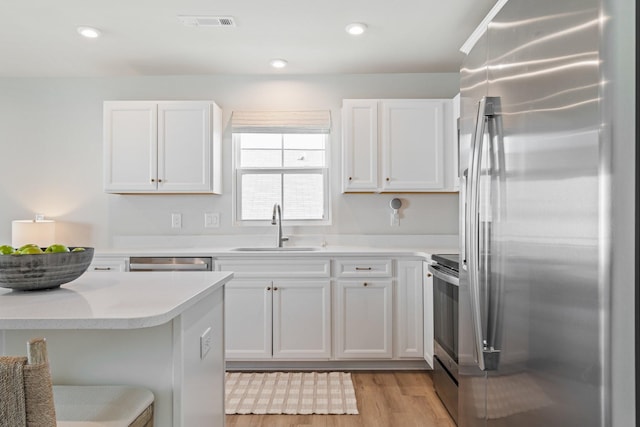2720 Thornton Grove Blvd, Nashville, TN 37207 - kitchen featuring appliances with stainless steel finishes, a sink, light wood finished floors, light countertops, and white cabinetry