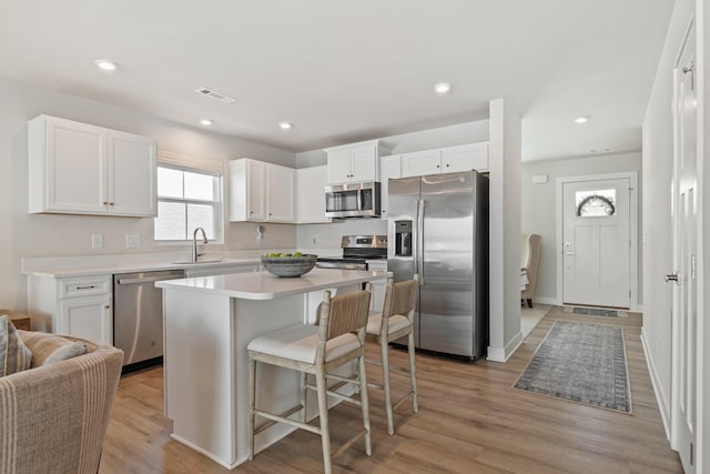 2720 Thornton Grove Blvd, Nashville, TN 37207 - kitchen with appliances with stainless steel finishes, a sink, white cabinetry, a breakfast bar, and light countertops