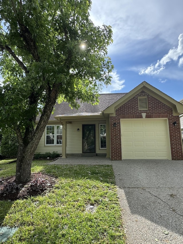 single story home with a garage, brick siding, driveway, and a front yard