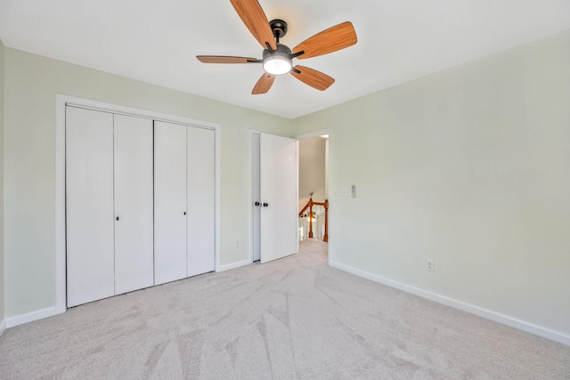 unfurnished bedroom featuring carpet flooring, baseboards, a closet, and ceiling fan