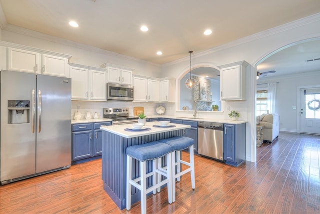 1008 Beverly Ln, Spring Hill, TN 37174 - kitchen with stainless steel appliances, blue cabinets, light countertops, dark wood-style flooring, and recessed lighting