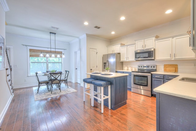 1008 Beverly Ln, Spring Hill, TN 37174 - kitchen with stainless steel appliances, white cabinets, light countertops, a kitchen island, and baseboards