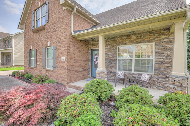 1008 Beverly Ln, Spring Hill, TN 37174 - property entrance with a porch, stone siding, and roof with shingles