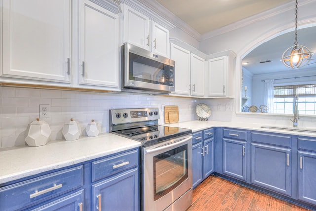 1008 Beverly Ln, Spring Hill, TN 37174 - kitchen with stainless steel appliances, blue cabinets, a sink, crown molding, and white cabinets