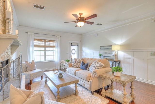 1008 Beverly Ln, Spring Hill, TN 37174 - living room with a decorative wall, a ceiling fan, wood finished floors, ornamental molding, and a stone fireplace