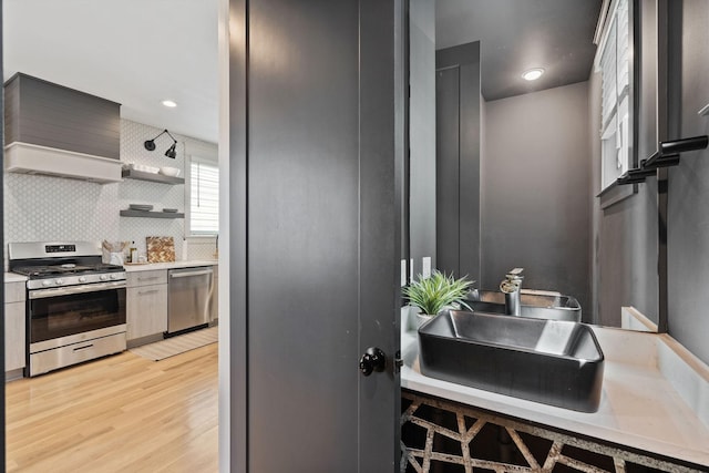 6003B Pennsylvania Ave, Nashville, TN 37209 - kitchen with stainless steel appliances, light wood-type flooring, decorative backsplash, light countertops, and open shelves