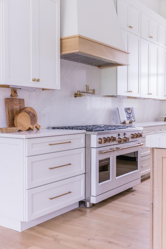 2576 Goose Creek Byp, Franklin, TN 37064 - kitchen with custom exhaust hood, double oven range, white cabinetry, light countertops, and decorative backsplash