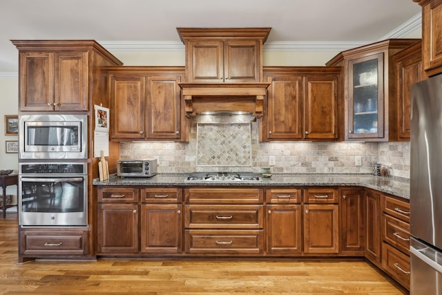 6611 Arno College Grove Rd, College Grove, TN 37046 - kitchen with appliances with stainless steel finishes, dark stone counters, glass insert cabinets, backsplash, and ornamental molding