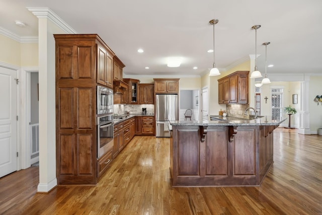 6611 Arno College Grove Rd, College Grove, TN 37046 - kitchen with appliances with stainless steel finishes, a peninsula, a breakfast bar area, stone counters, and light wood-style flooring