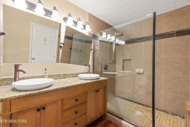 338 Lindsey Mill Cir, Rocky Top, TN 37769 - full bathroom with tiled shower, double vanity, and a textured ceiling