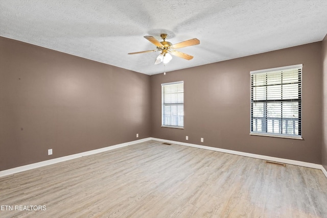 338 Lindsey Mill Cir, Rocky Top, TN 37769 - unfurnished room with light wood finished floors, a ceiling fan, baseboards, and a textured ceiling