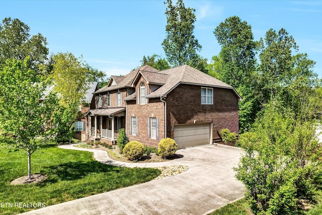 5606 Bridgehampton Dr, Powell, TN 37849 - traditional home with concrete driveway, brick siding, a garage, a front yard, and a porch