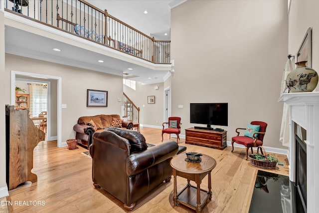 5606 Bridgehampton Dr, Powell, TN 37849 - living room featuring a towering ceiling, stairway, a fireplace with flush hearth, light wood-style floors, and baseboards