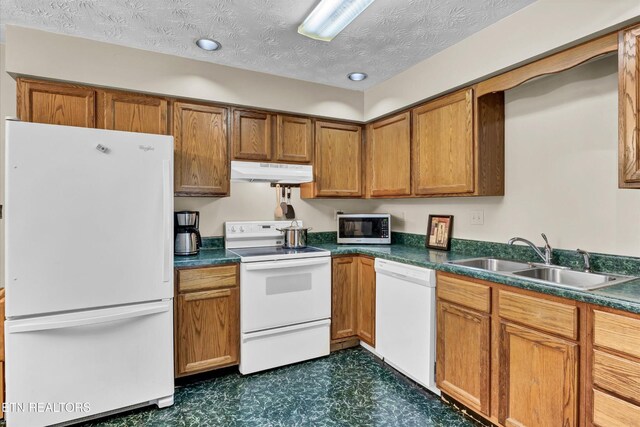 2406 Rowena Ln, Knoxville, TN 37931 - kitchen with white appliances, under cabinet range hood, a sink, dark floors, and brown cabinetry