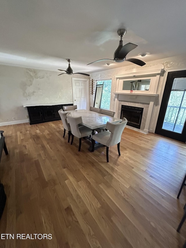 1939 Pinewood Cv, Cleveland, TN 37312 - dining room with ceiling fan, a tiled fireplace, wood finished floors, and baseboards
