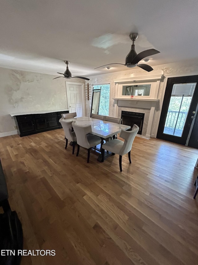 1939 Pinewood Cv, Cleveland, TN 37312 - dining room featuring ceiling fan, a tiled fireplace, and wood finished floors