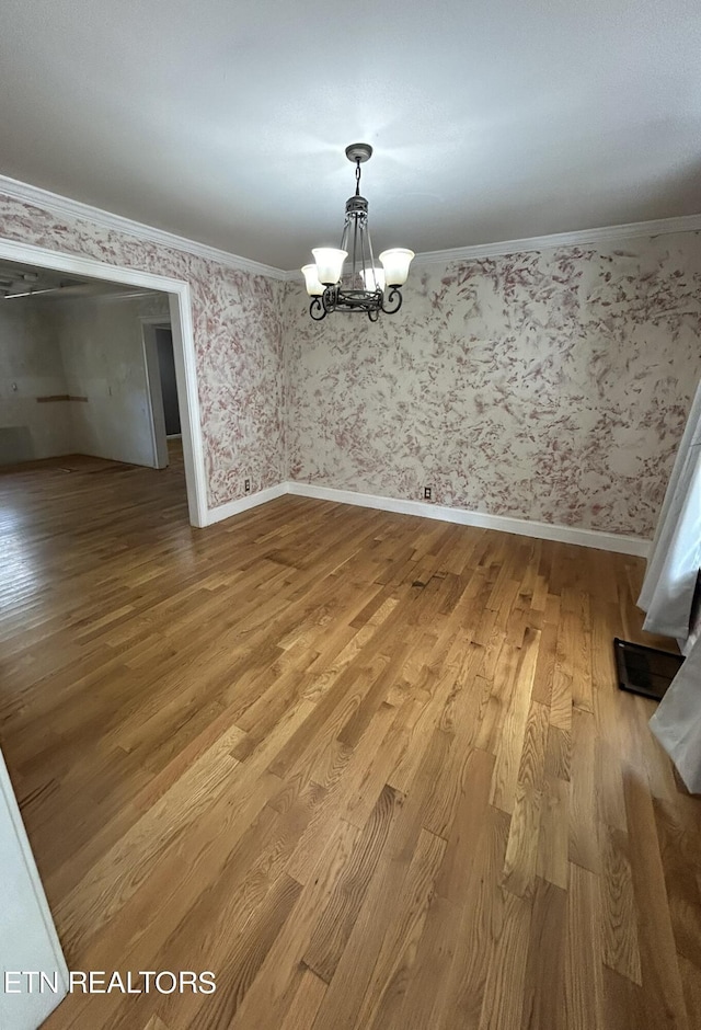 1939 Pinewood Cv, Cleveland, TN 37312 - unfurnished dining area with a chandelier, light wood-style flooring, crown molding, and wallpapered walls
