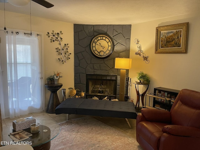 sitting room featuring tile patterned floors, a fireplace, and a ceiling fan