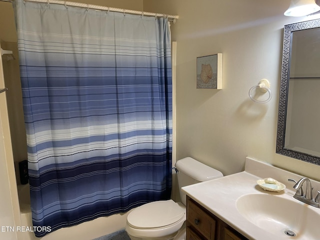 bathroom with toilet, vanity, and shower / tub combo