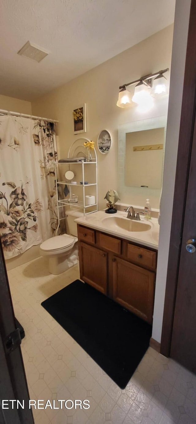 full bathroom featuring vanity, toilet, tile patterned floors, and curtained shower