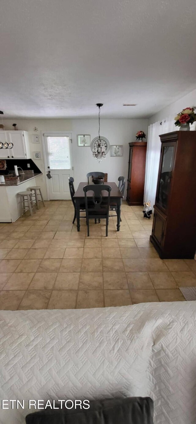 dining area with a chandelier and light tile patterned flooring