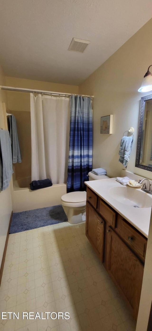 bathroom with toilet, shower / bathtub combination with curtain, and vanity