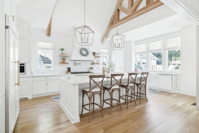 kitchen with light wood-style flooring, light countertops, white cabinets, and a kitchen island