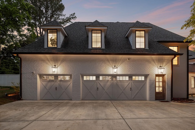 garage at dusk featuring driveway