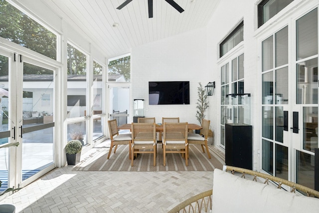 sunroom / solarium featuring ceiling fan, outdoor dining space, and vaulted ceiling