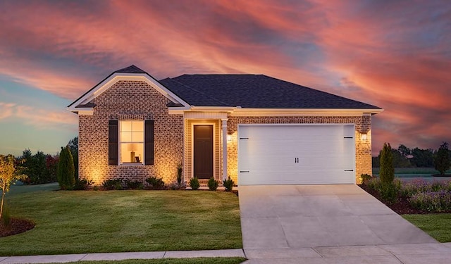view of front of property with brick siding, driveway, an attached garage, a front yard, and a shingled roof