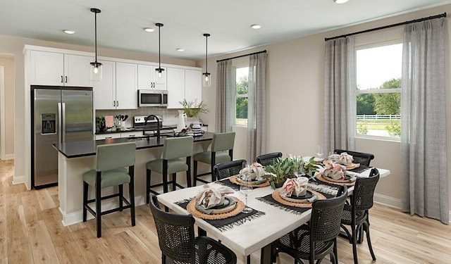dining space featuring plenty of natural light, recessed lighting, light wood-type flooring, and baseboards