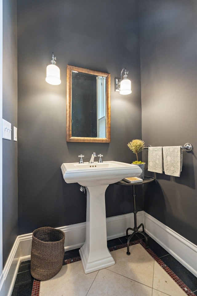 bathroom with tile patterned flooring, a sink, and baseboards