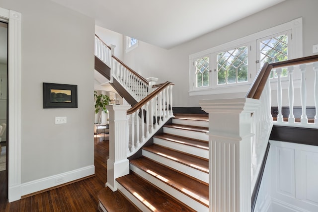 stairs with wood finished floors and baseboards