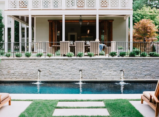 back of house featuring an outdoor pool and fence
