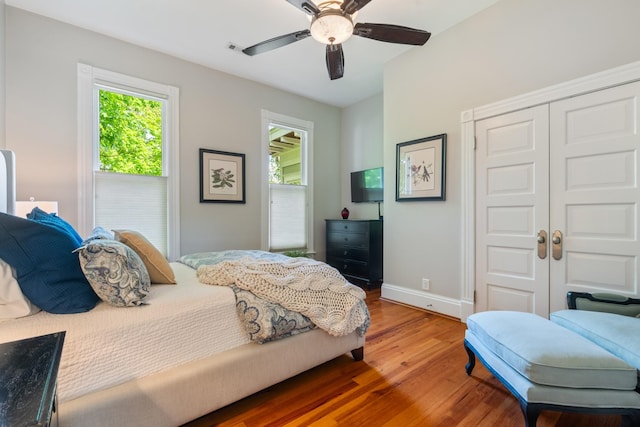 bedroom featuring wood finished floors, baseboards, a closet, and a ceiling fan