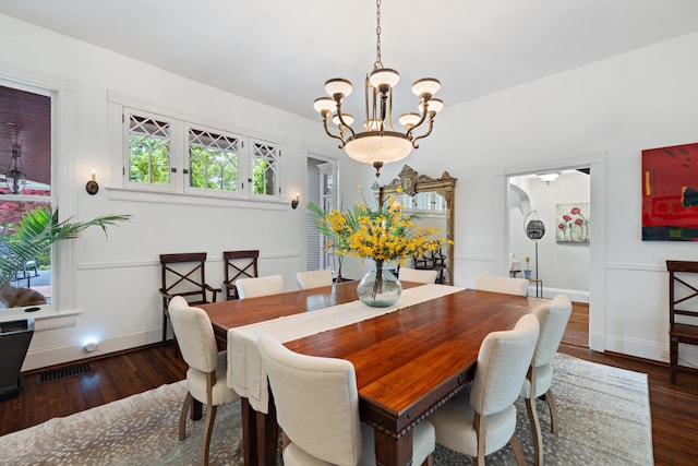 dining area featuring a chandelier, wood finished floors, and baseboards